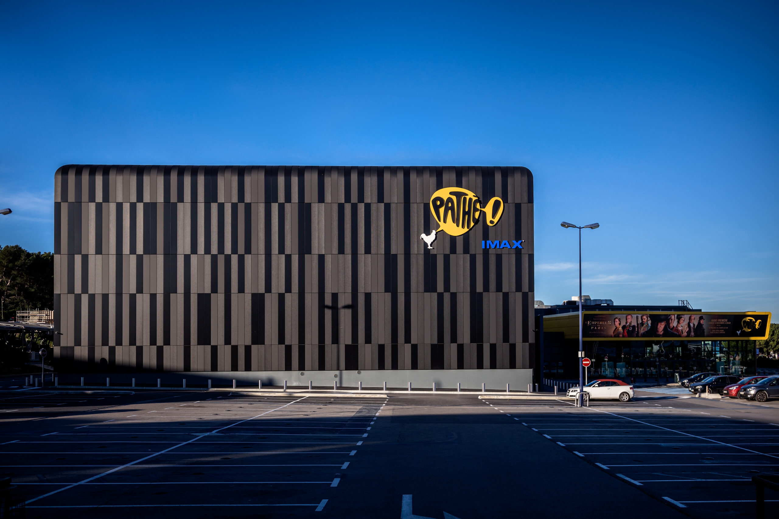 Façade extérieure du cinéma à la lumière du jour avec le logo Pathé apparent.