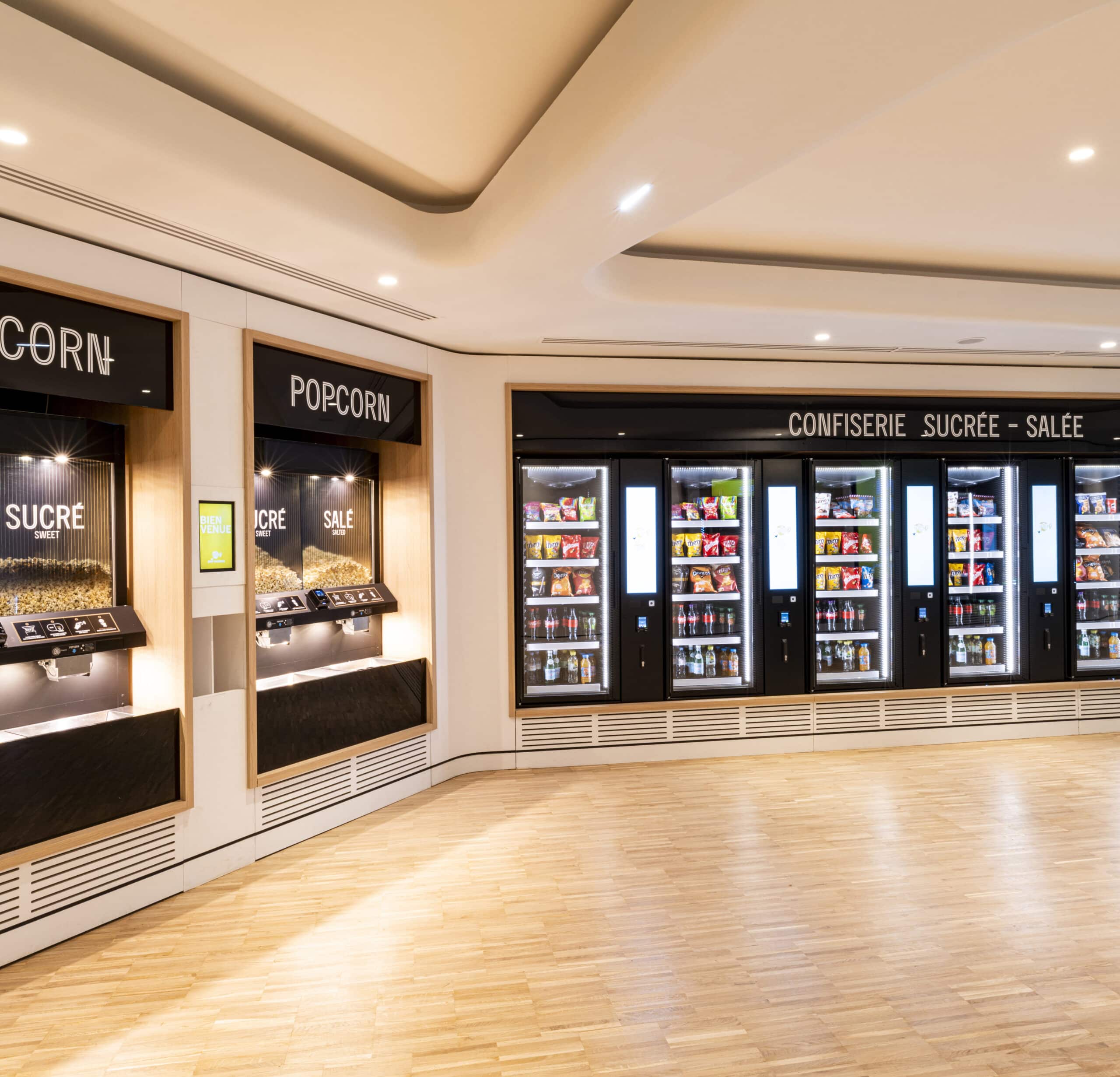 Espace confiserie du cinéma Pathé avec comptoir de pop-corn, distributeurs de boissons en libre-service.