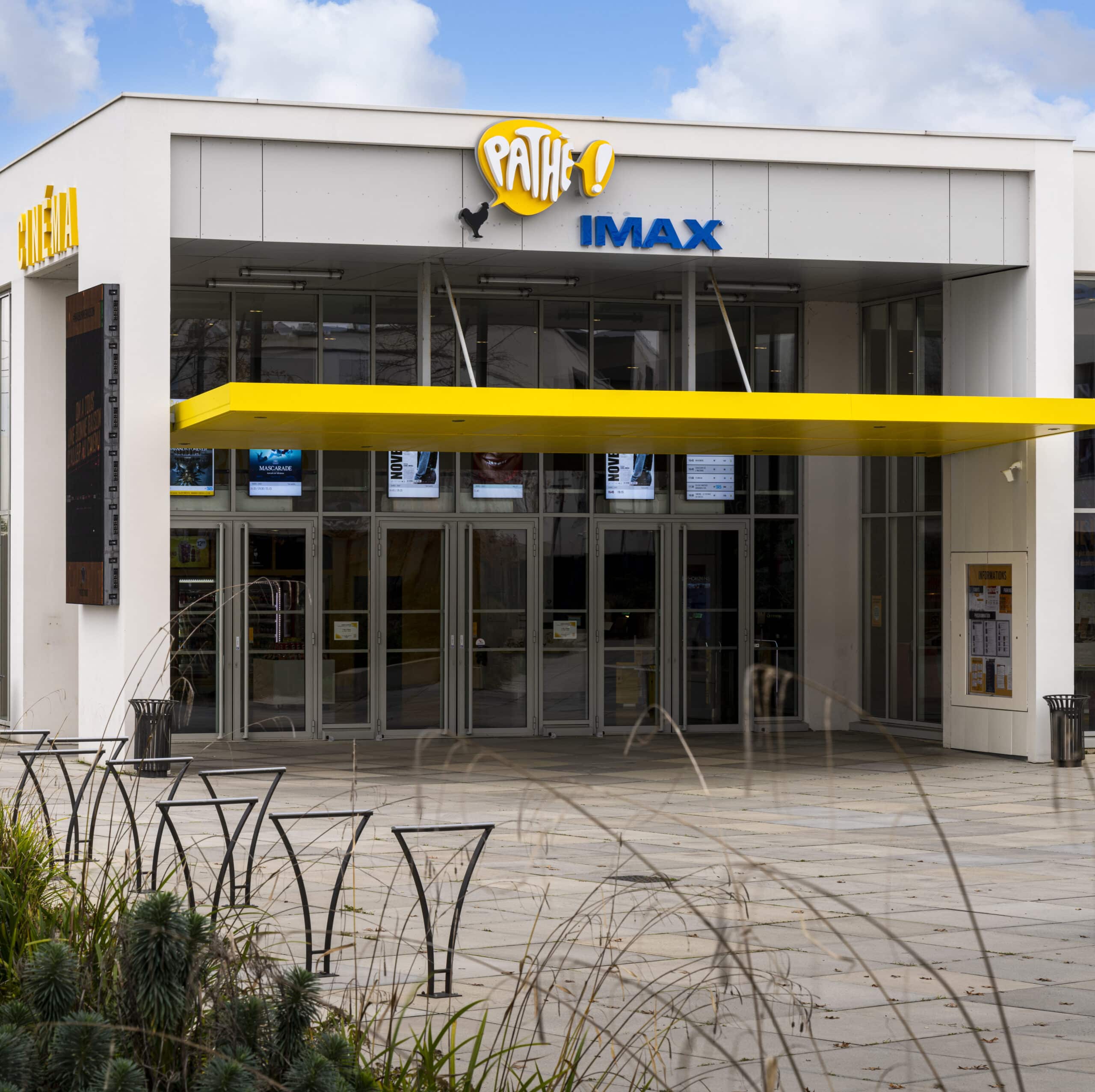 Façade extérieure du cinéma à la lumière du jour avec le logo Pathé et IMAX apparent.