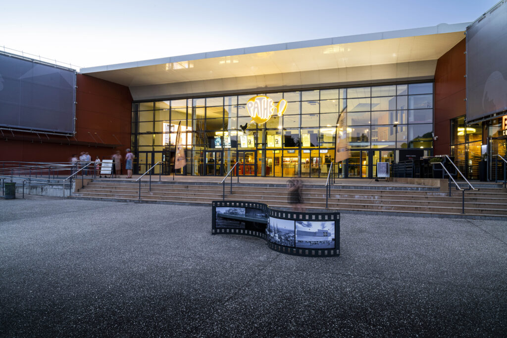 Façade extérieure du cinéma éclairée à la tombée de la nuit.